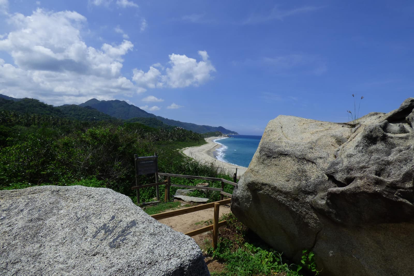 Palms, granite headland, and open Caribbean where the Sierra Nevada meets the coast.