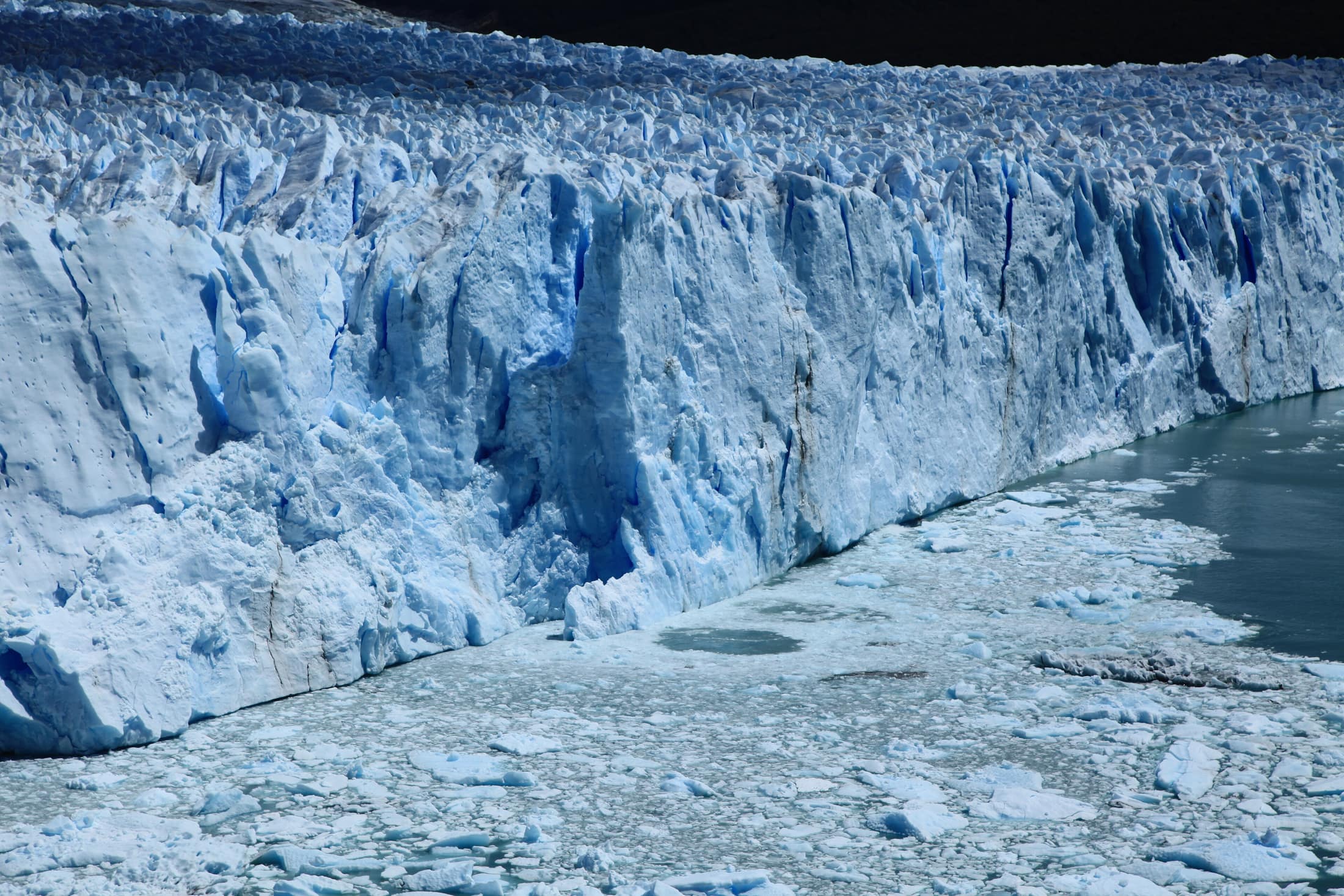A block of ice breaking off the face of Perito Moreno into the channel.