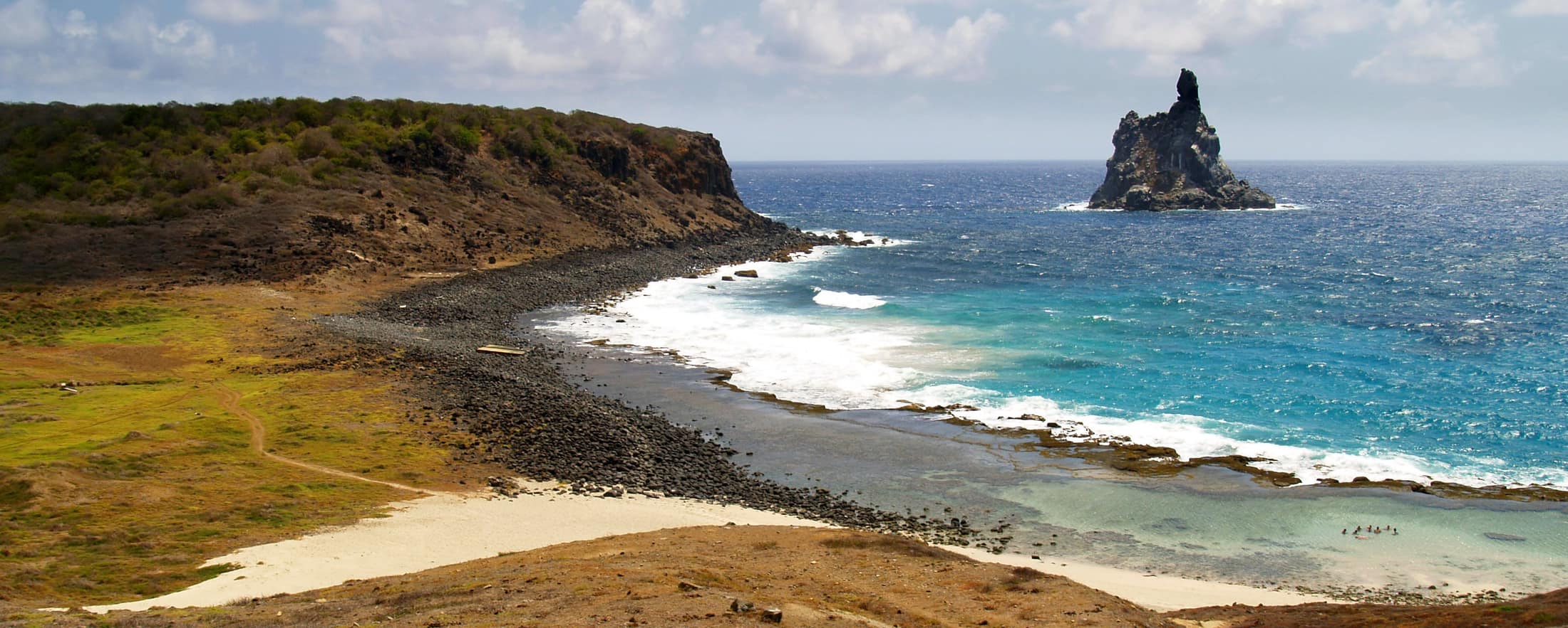 Reef pool, black rock, and Atlantic surf breaking on the outer edge.