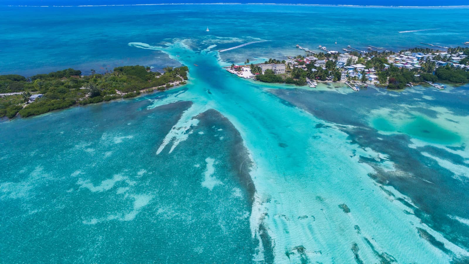 Reef shallows and channel cutting past a low caye on the Belize barrier reef.