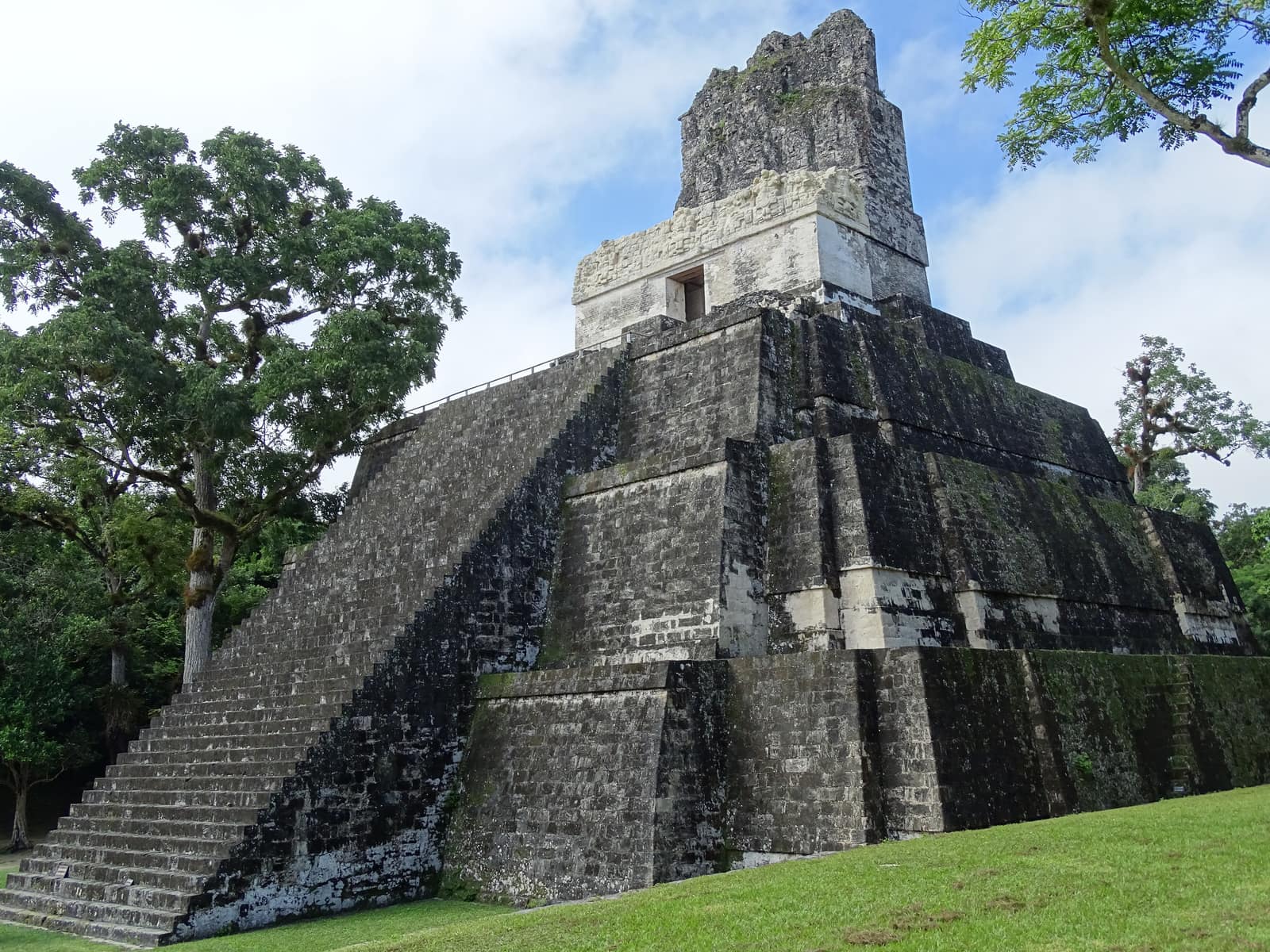 Temple II standing over the Gran Plaza at Tikal under heavy cloud.
