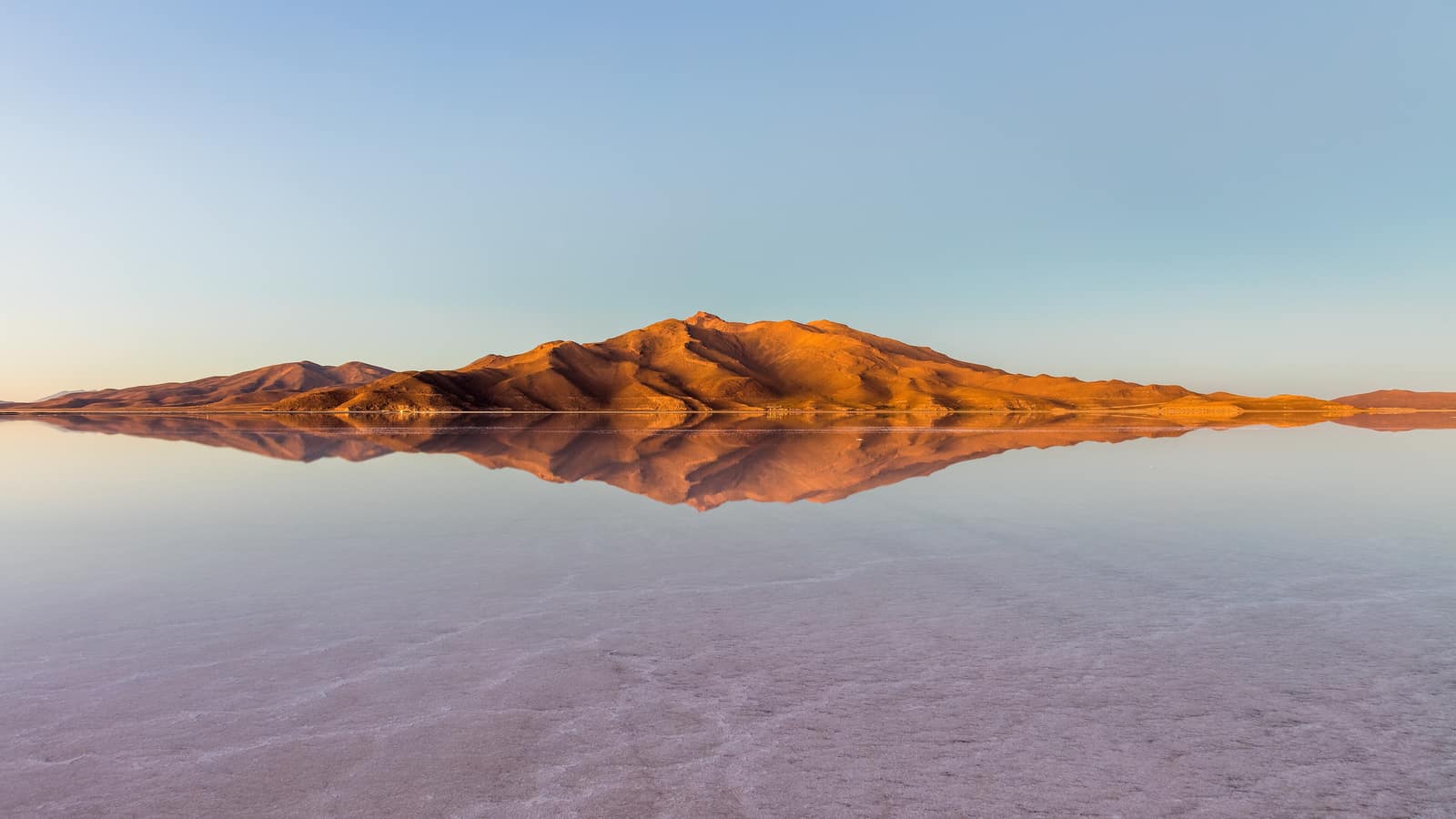 The salt crust of Uyuni running flat to the horizon under cloud.